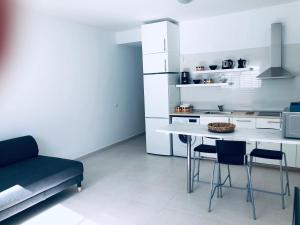 Una cocina con una mesa y sillas en una habitación. en Suite ladybird, en Breña Baja