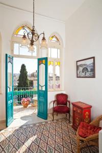 a living room with a colorful door and a chair at Al Mutran Guest House in Nazareth