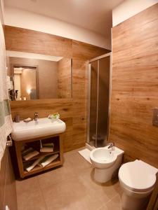ein Bad mit einem Waschbecken, einem WC und einer Dusche in der Unterkunft Hotel Smeraldo in Qualiano