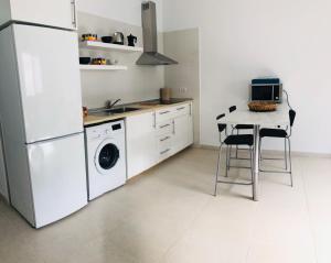 Una cocina con una mesa y un refrigerador blanco. en Suite ladybird, en Breña Baja 2 fotos más