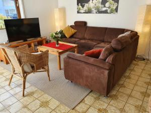 sala de estar con sofá y TV en Ferienwohnung Urlaub im Kraichgau, en Sinsheim