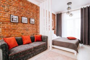 a living room with a couch and a brick wall at 10 Apartment on ploshad Pobedi in Minsk