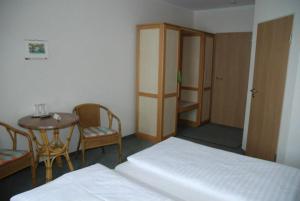 a room with a bed and a table and chairs at Räuberschänke in Oederan