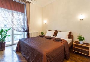 a bedroom with a bed and a large window at 10 Apartment on ploshad Pobedi in Minsk
