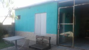 Casa azul con mesa, mesa y sillas en Monoambientes Sandú, en Durazno