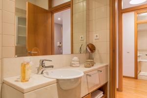 un baño con lavabo y espejo en River View Apartment by Lisbon Heart, en Lisboa 24 fotos más