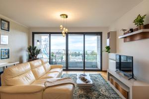 uma sala de estar com um sofá e uma grande janela em River View Apartment by Lisbon Heart em Lisboa