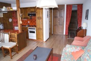 a kitchen and living room with a couch and a table at Les Collons1800- Bel appart 2pièces-4 pers-piscine-sauna-parking int-Wifi gratuit in Vex