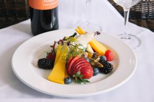 a plate of fruit and vegetables on a table with a bottle of wine at The Brunswick Hotel in Brunswick