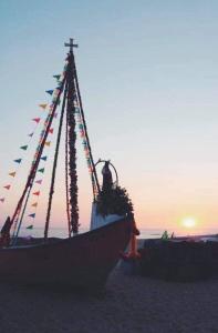 Un barco en la playa con banderas. en Casa da Fátima,, en Vila Chã