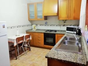 a small kitchen with a sink and a table at Casa da Fátima, in Vila Chã +26 photos