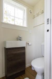 a bathroom with a sink and a toilet at The little cottage in Tauranga +36 photos