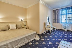 ein Hotelzimmer mit einem Bett, einem Tisch und Stühlen in der Unterkunft Evergreen apartments hotel in Karlsbad
