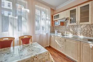 eine Küche mit einem Tisch und Stühlen sowie einem Tisch und einem Fenster in der Unterkunft Evergreen apartments hotel in Karlsbad