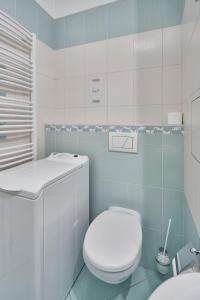 a white bathroom with a toilet and a sink at Evergreen apartments hotel in Karlovy Vary