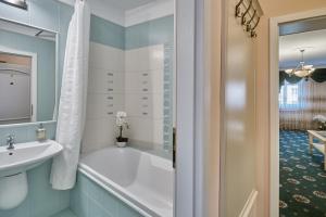 een badkamer met een bad en een wastafel bij Evergreen apartments hotel in Karlsbad