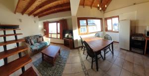 a living room with a table and a couch at Ushuhouse Apartments in Ushuaia