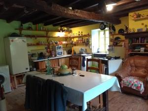 - une cuisine avec une table blanche dans une pièce dans l'établissement la maison du bonheur chez Yann HUMBLET, à Moulis