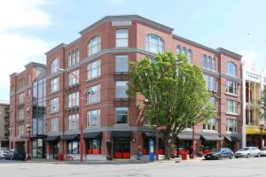 a large red brick building on a street corner at Clean 3rd Floor 1 BR Apt in Old Town China Town in Victoria