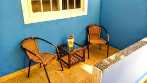 two chairs and a table in a blue room at Casarão Praia Barra Da Tijuca 16 Hóspedes in Rio de Janeiro