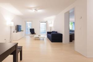 een woonkamer met een bank en een tafel bij 2,5 Zi Design Loft Wohnung mit Gartensitzplatz in Bazel