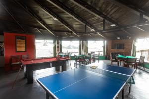 a ping pong table in a room with tables and chairs at Hotel Fazenda Rota dos Cânions in Bom Jardim da Serra