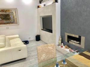 ein Wohnzimmer mit einer weißen Couch und einem Kamin in der Unterkunft Allegra's House Vaticano in Rom