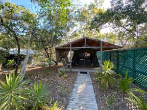 a house with a wooden walkway in a garden at Great Keppel Island Holiday Village in Great Keppel