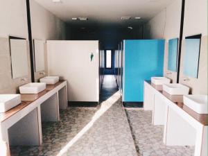 een badkamer met vier wastafels en een rij spiegels bij Seahorse Lipe Hostel in Ko Lipe +26 foto's