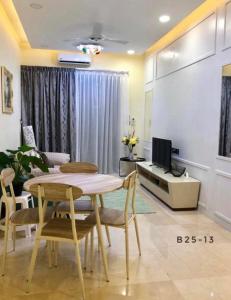 a living room with a table and chairs and a television at Silverscape Seaview B25-13 in Malacca