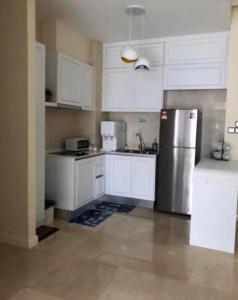 uma cozinha com armários brancos e um frigorífico de aço inoxidável em Silverscape Seaview B25-13 em Malaca