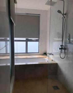 a bathroom with a bath tub and a window at Silverscape Seaview B25-13 in Malacca
