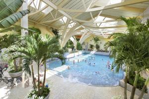 a large swimming pool with people in a building at Center Parcs Bostalsee Saarland in Nohfelden