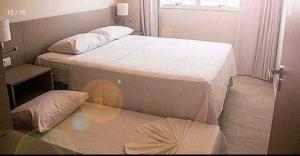 2 aparte bedden in een kamer met een raam bij Salinas Park Resort in Salinópolis