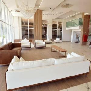 a large living room with white furniture and a chandelier at Salinas Park Resort in Salinópolis