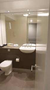 a bathroom with a sink and a toilet and a mirror at Melbourne Kew Central Apartments Official in Melbourne
