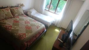 a bedroom with a bed and a tv and a window at Nomeolvides in Tandil +22 photos