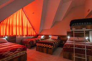 a attic room with two beds and a window at The Traveler Hostel in Otavalo