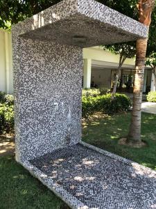 eine große Steinmauer in einem Hof mit einem Baum in der Unterkunft The Loft Imago in Kota Kinabalu
