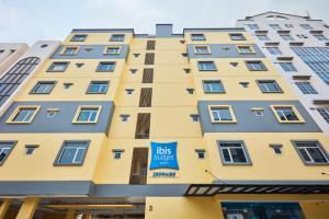 Un bâtiment jaune avec un panneau de hall. dans l'établissement ibis budget Singapore Sapphire, à Singapour