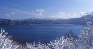 a large body of water with mountains in the background at Hotel Towadaso in Towada