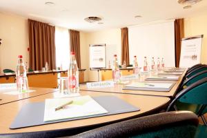 una sala de reuniones con una larga mesa con botellas. en Campanile Montpellier Est Le Millénaire, en Montpellier