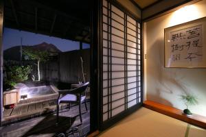 a room with a window with a table and a chair at Yufuin Bath Satoyamasafu in Yufu