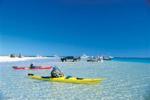 two people in kayaks in the water on a beach at Ningaloo Coral Bay Backpackers in Coral Bay