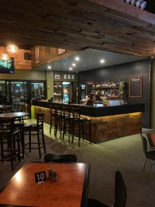 a restaurant with tables and chairs and a bar at Biloela Hotel in Biloela
