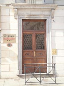 a wooden door with a sign in front of a building at Affittacamere Maison Napoleon in Turin