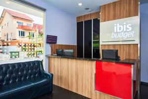 a restaurant with a black leather bench in front of a counter at ibis budget Singapore West Coast in Singapore