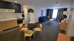 a kitchen and a living room with a table and chairs at The Astor Suites in Goulburn