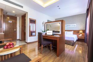 a hotel room with a desk with a bed and a mirror at Saigon Hotel Dong Du in Ho Chi Minh City