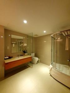 a bathroom with a tub and a sink and a shower at Saigon Hotel in Ho Chi Minh City